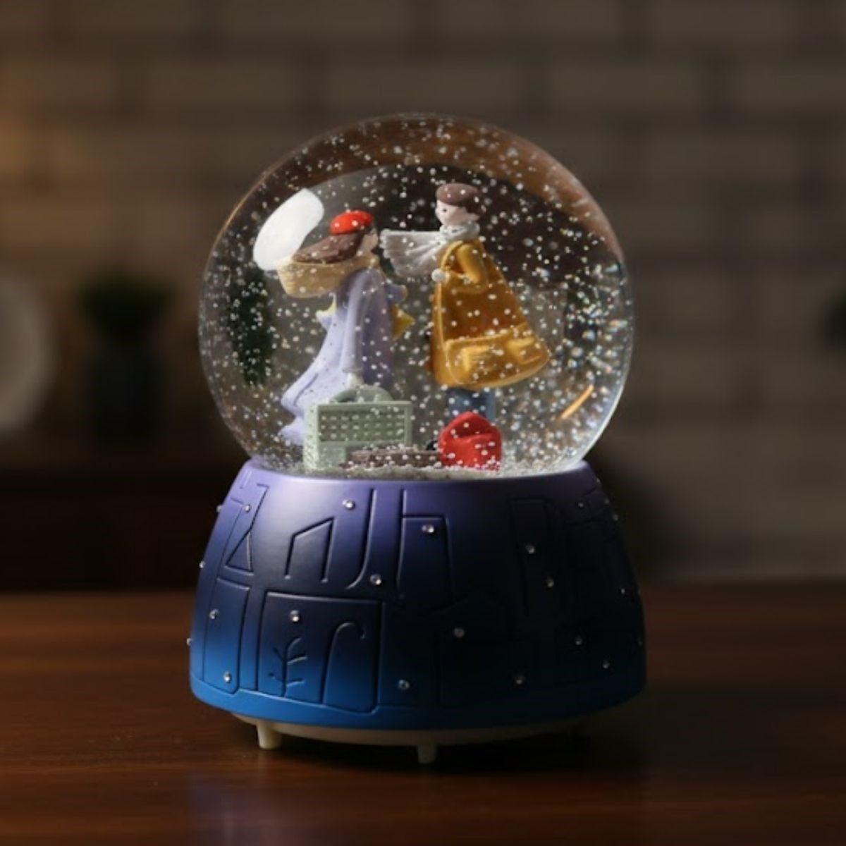 Battery-Operated, Light-Up, Musical Snow Globe - Fun Desktop Ornament with Couple in Suitcase Figurine, LED Illuminated Decorative Gift Snow Globe (5347)